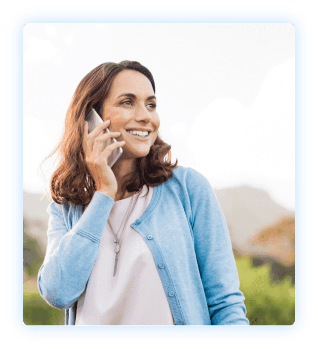 Smiling person holding a phone to their ear.