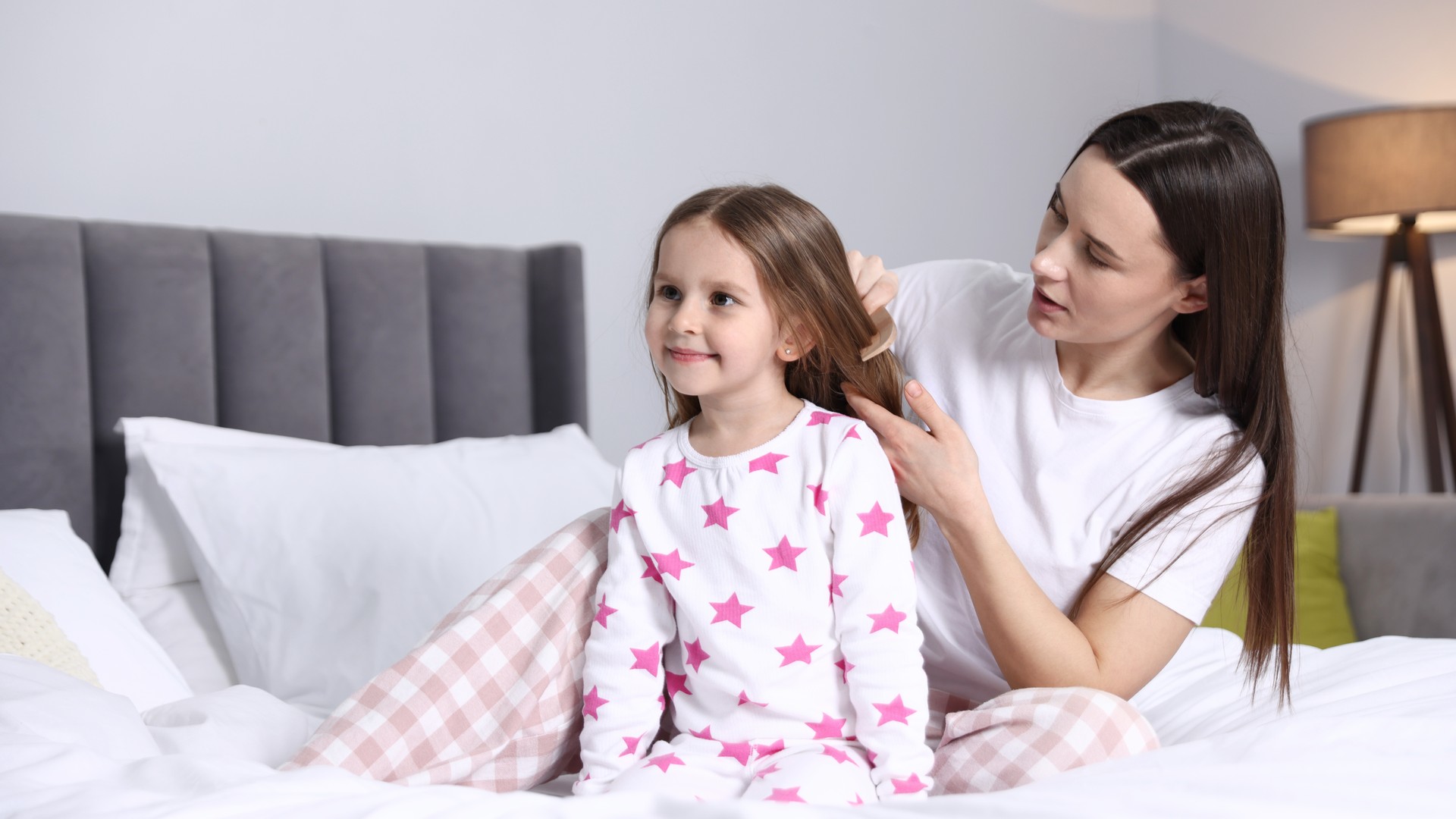 Parent checking child hair at home after finding lice.