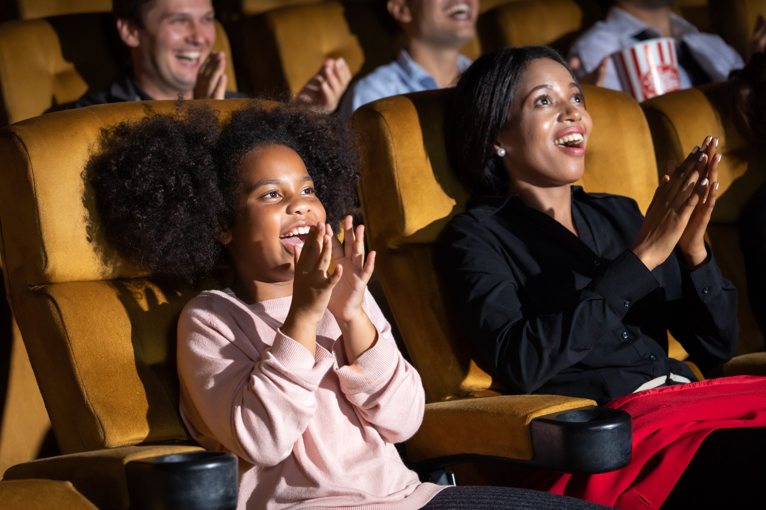 Family in a movie theater for article about head lice risk in public places